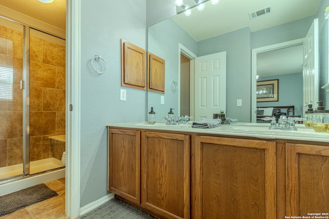 bathroom featuring vanity, tile patterned flooring, toilet, and a shower with door