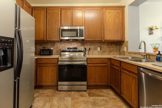 kitchen featuring appliances with stainless steel finishes, decorative backsplash, and sink