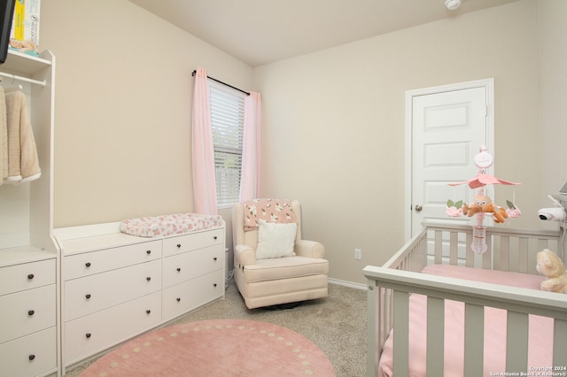 bedroom featuring light carpet and a crib