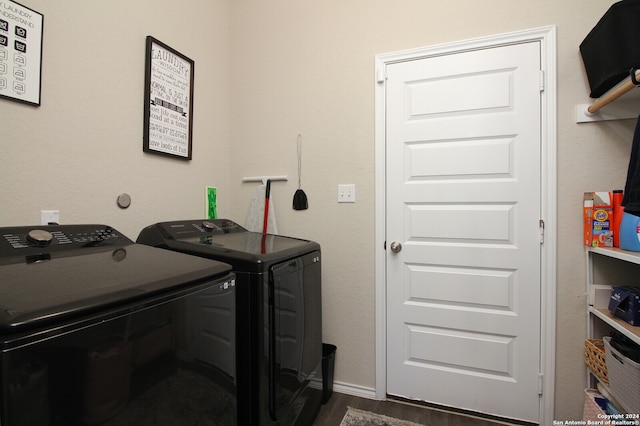 washroom with washing machine and clothes dryer and dark hardwood / wood-style floors