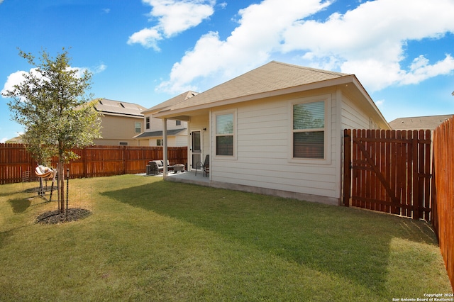 rear view of property featuring a patio and a yard