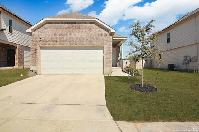 view of front facade featuring a front yard, central AC, and a garage