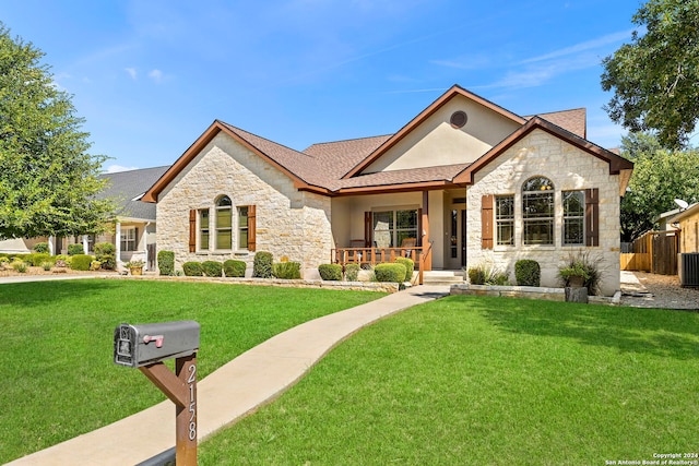 view of front facade featuring a front lawn, covered porch, and central AC unit