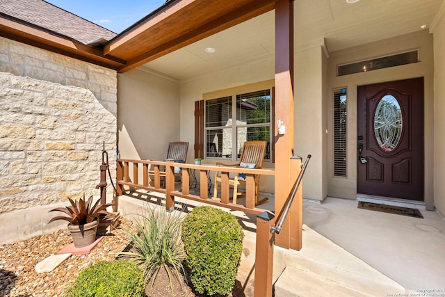 view of exterior entry featuring covered porch