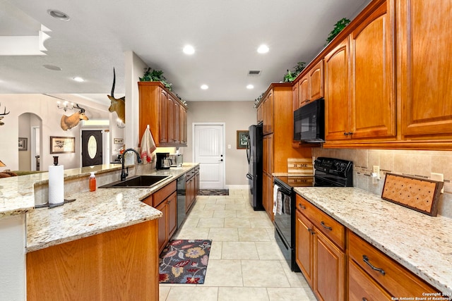 kitchen featuring decorative backsplash, sink, black appliances, light tile patterned floors, and light stone counters