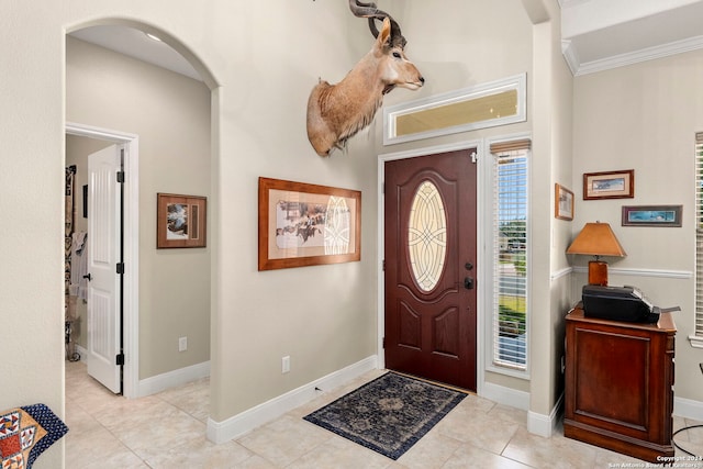 entryway with crown molding and light tile patterned floors