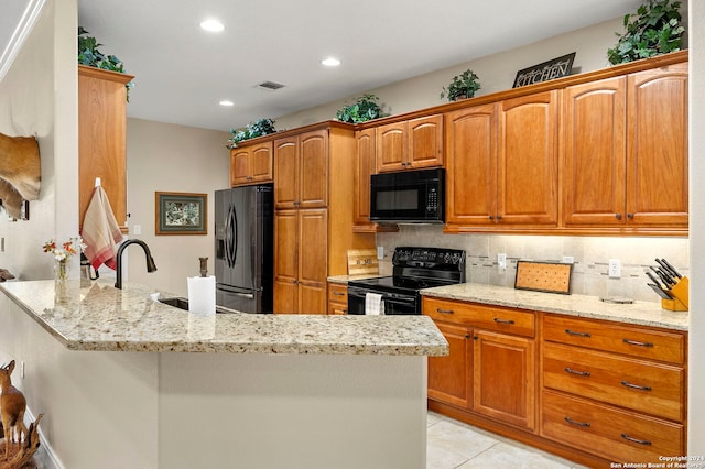 kitchen with black appliances, light stone counters, backsplash, and light tile patterned floors