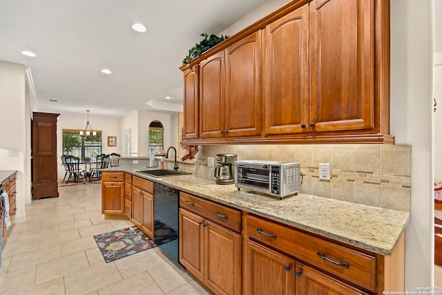 kitchen featuring decorative backsplash, light stone counters, dishwasher, sink, and decorative light fixtures