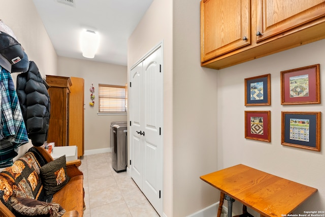 washroom featuring cabinets, independent washer and dryer, and light tile patterned floors