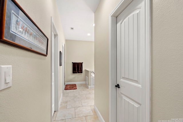 hall featuring light tile patterned floors