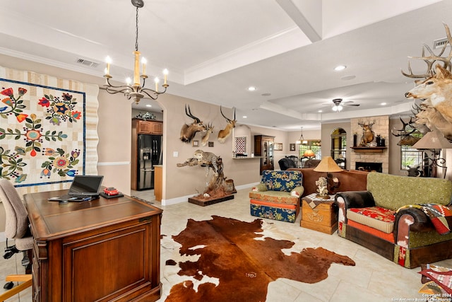 interior space featuring ornamental molding, a stone fireplace, a tray ceiling, and ceiling fan with notable chandelier