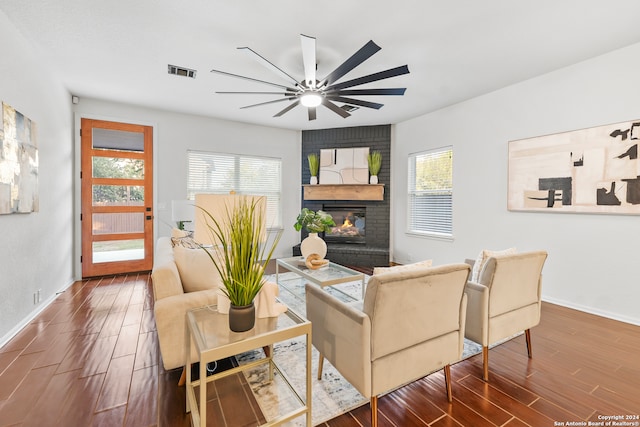 living room with ceiling fan, wood-type flooring, and a fireplace