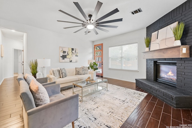 living room with ceiling fan, a fireplace, and dark hardwood / wood-style flooring