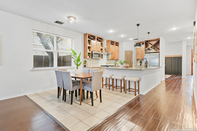 dining area with sink and light wood-type flooring