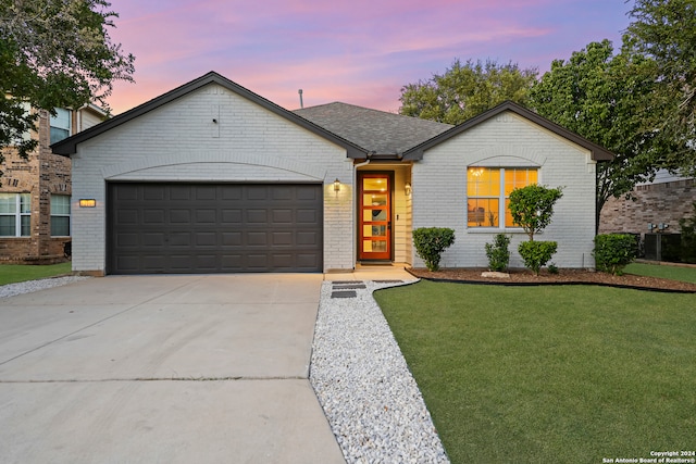 view of front of home with a yard and a garage