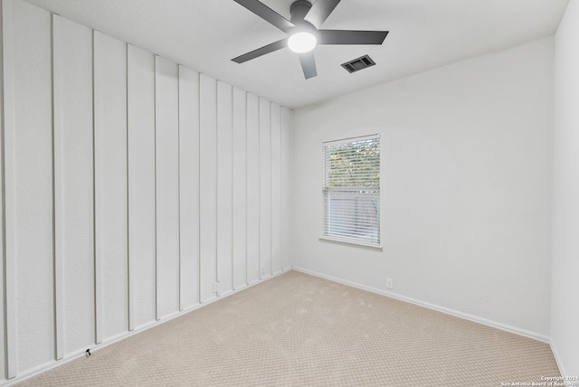 carpeted spare room with ceiling fan