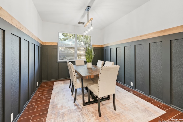 dining area featuring vaulted ceiling, dark hardwood / wood-style flooring, and a chandelier