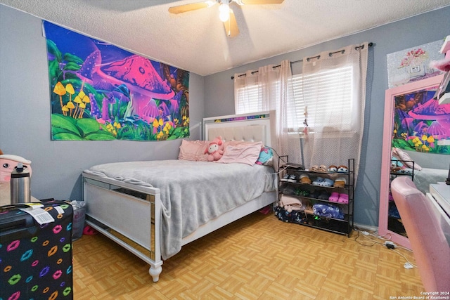 bedroom with ceiling fan, a textured ceiling, and parquet floors