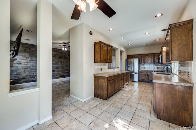 kitchen featuring tasteful backsplash, ceiling fan, light tile patterned floors, sink, and stainless steel appliances