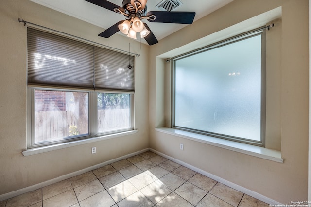 empty room with ceiling fan and light tile patterned floors