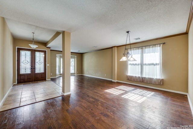 entryway featuring french doors, a textured ceiling, hardwood / wood-style flooring, and crown molding