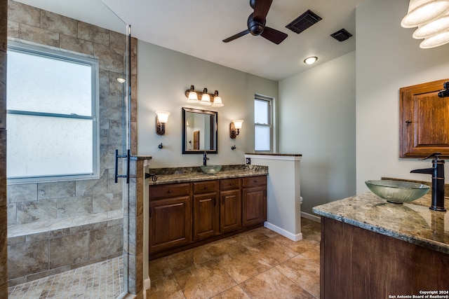 bathroom featuring vanity, ceiling fan, a shower with shower door, and a wealth of natural light