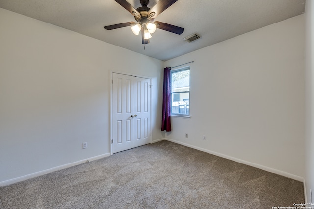 carpeted spare room featuring ceiling fan