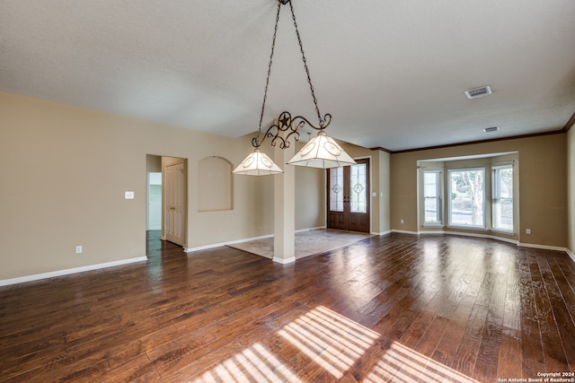 empty room featuring french doors, hardwood / wood-style flooring, a textured ceiling, and ornamental molding