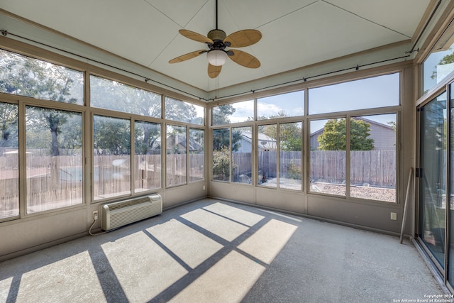 unfurnished sunroom featuring a wall mounted air conditioner, a healthy amount of sunlight, and ceiling fan