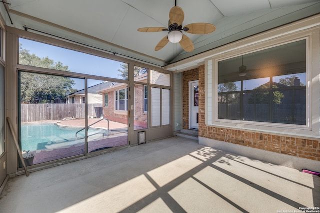 unfurnished sunroom with ceiling fan and vaulted ceiling