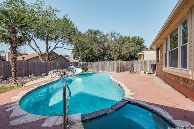 view of pool with an in ground hot tub and a patio