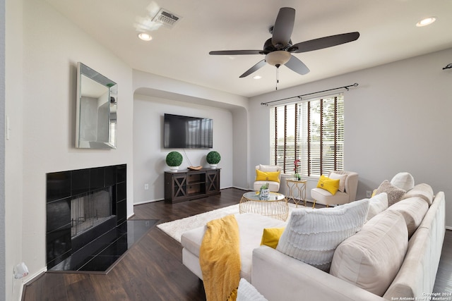 living room with dark hardwood / wood-style floors, a fireplace, and ceiling fan