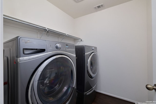 laundry area with washer and dryer and dark hardwood / wood-style floors