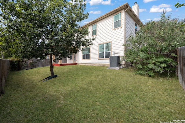 back of house with a yard and cooling unit