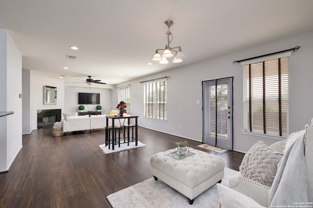 living room featuring dark hardwood / wood-style floors and ceiling fan with notable chandelier