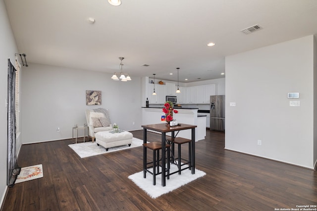 dining area with a chandelier and dark wood-type flooring