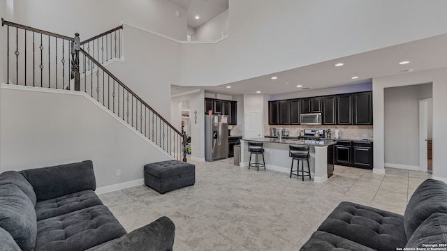 living room with a towering ceiling and light tile patterned floors