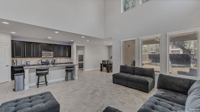 tiled living room with sink and a high ceiling