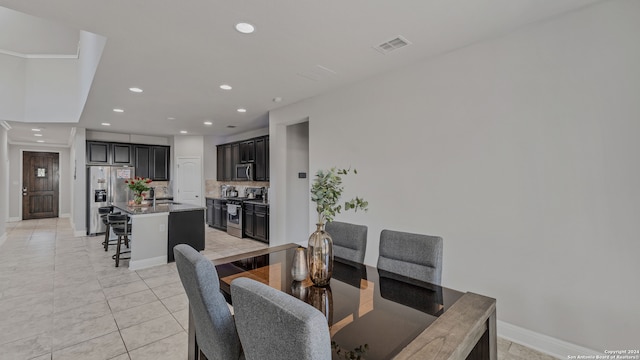 dining room featuring sink and light tile patterned floors