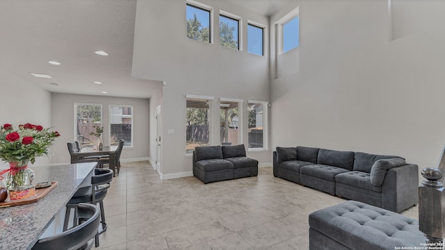 tiled living room featuring a towering ceiling