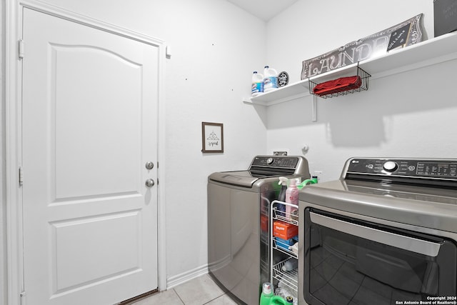 washroom featuring washer and clothes dryer and light tile patterned floors