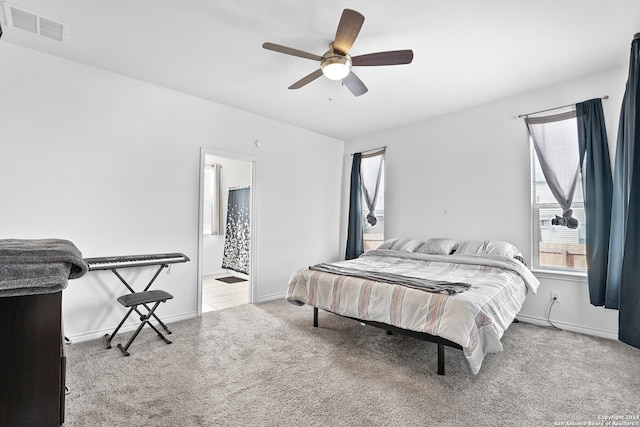 carpeted bedroom featuring ceiling fan and ensuite bathroom