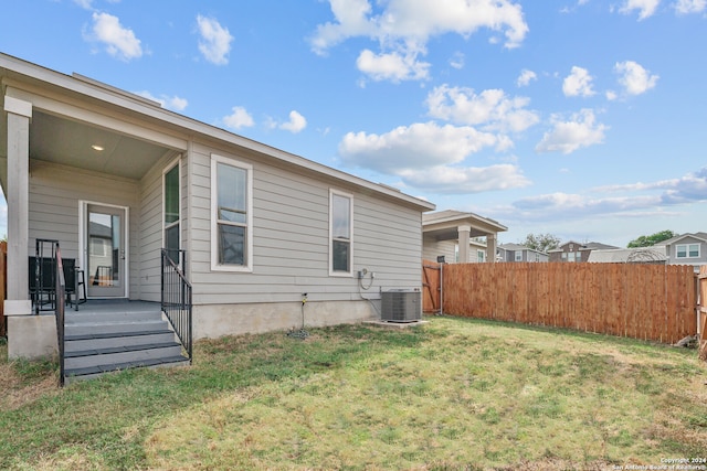 back of house featuring a yard and central AC unit