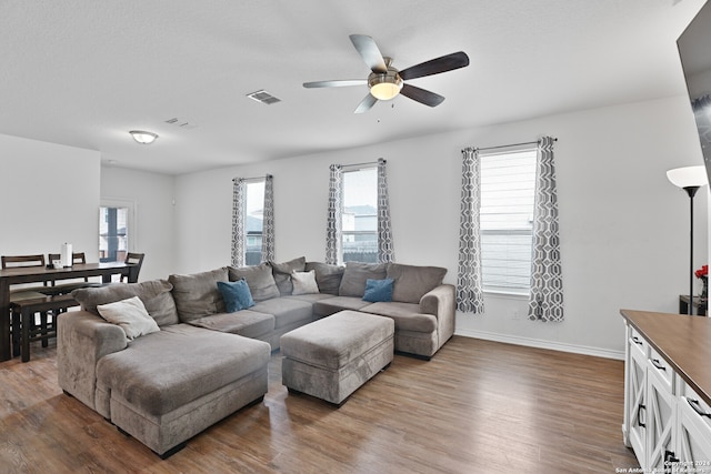 living room with hardwood / wood-style floors, plenty of natural light, and ceiling fan