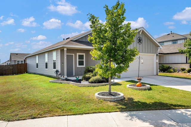 view of front of home with concrete driveway, fence, a garage, board and batten siding, and a front yard