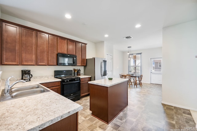 kitchen with a center island, hanging light fixtures, black appliances, and sink