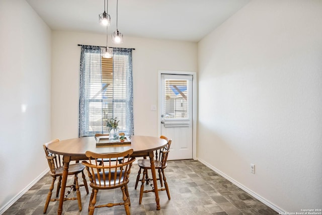 dining area featuring stone finish floor and baseboards