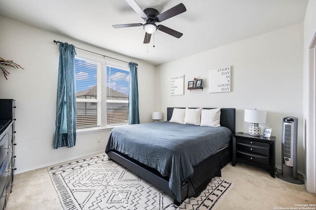 bedroom with light carpet, a ceiling fan, and baseboards