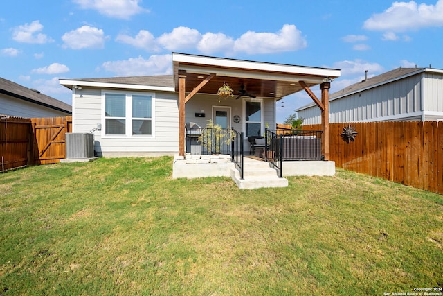 back of house featuring a patio area, central air condition unit, a ceiling fan, a fenced backyard, and a yard