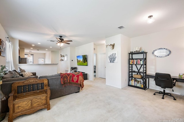 living area with carpet, visible vents, and a ceiling fan